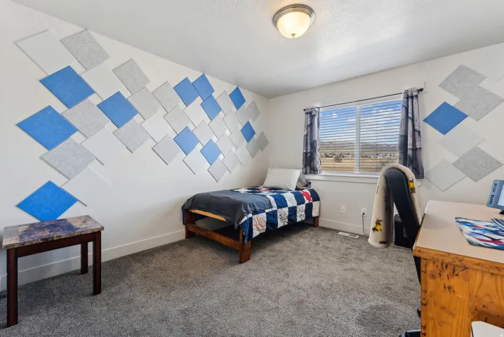Bedroom featuring dark carpet and baseboards