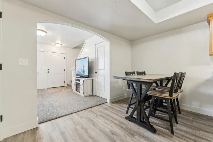 Dining room with arched walkways and light wood-style flooring