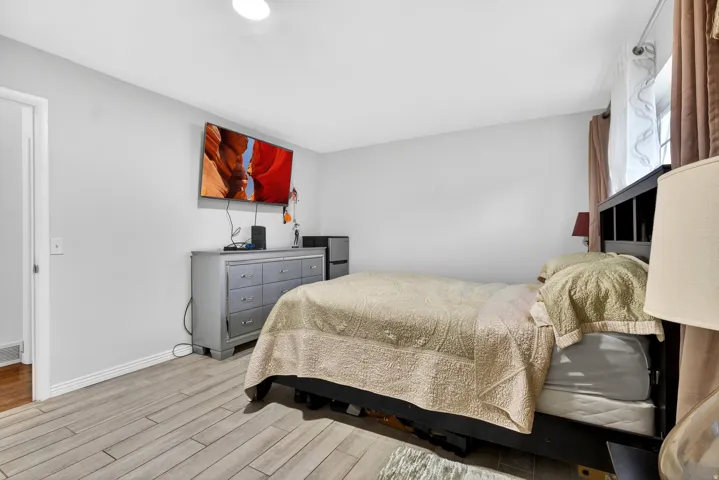 Bedroom featuring fridge and light wood-style floors