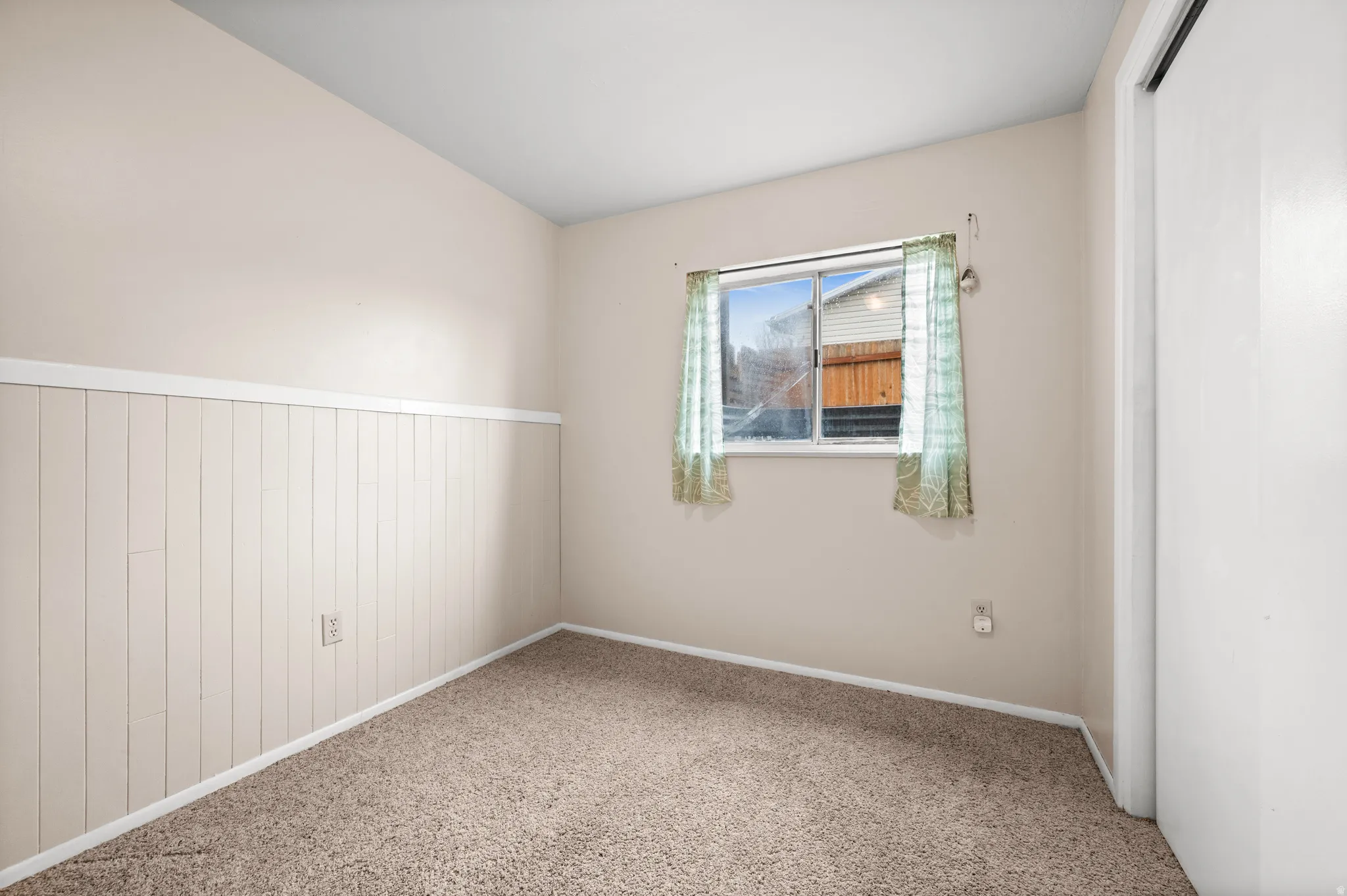 Bedroom with carpet and wainscoting