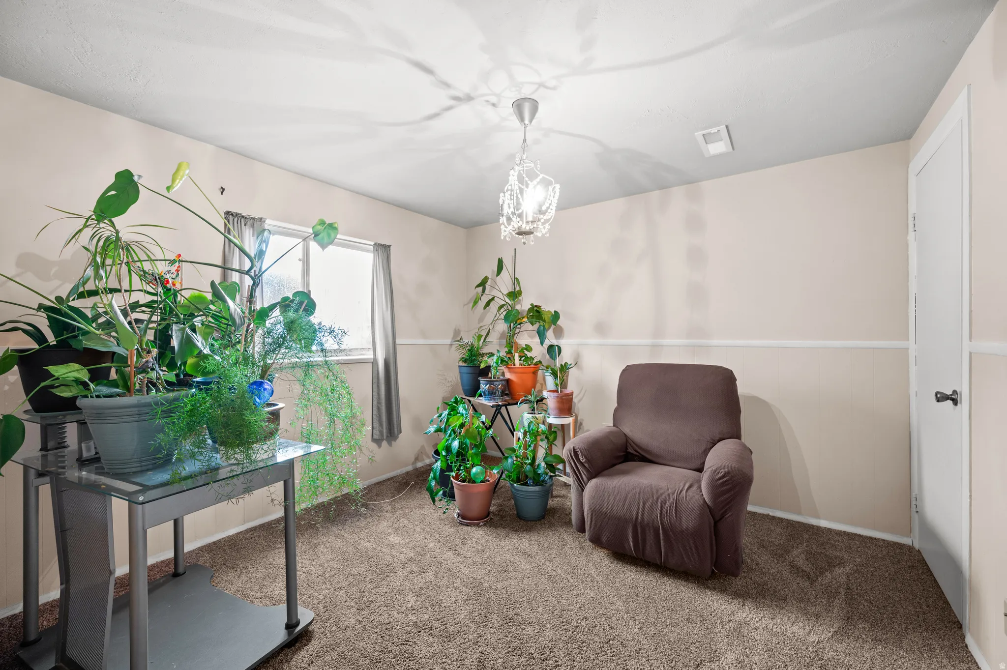 Downstairs Bedroom with carpet and chandelier