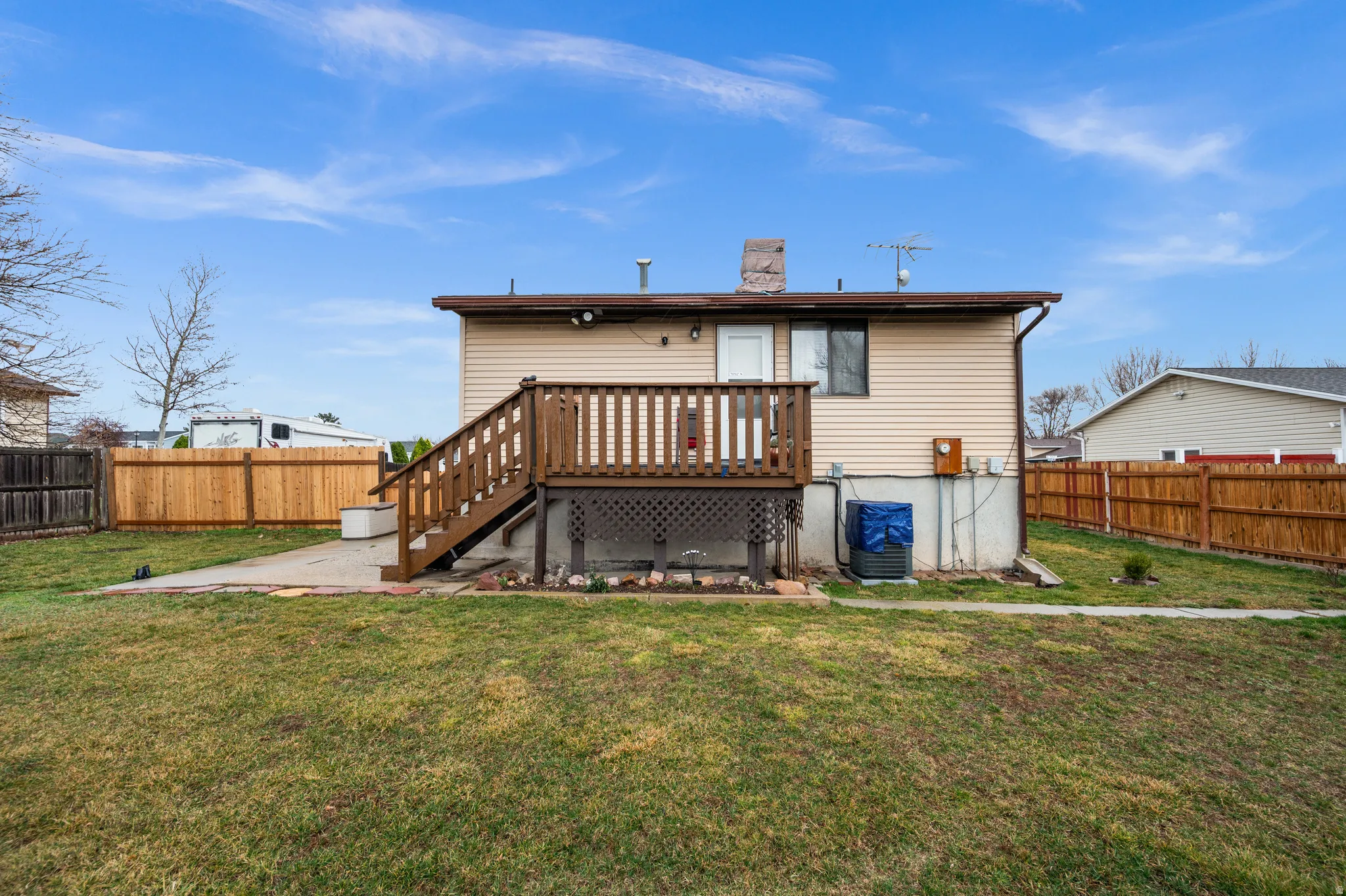 Back of house with a fenced backyard, a wooden deck, and a chimney