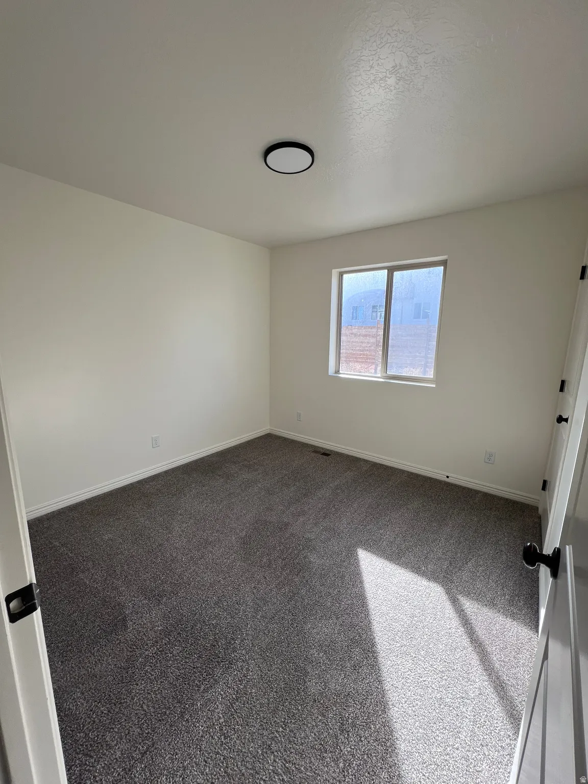 Spare room featuring baseboards and carpet