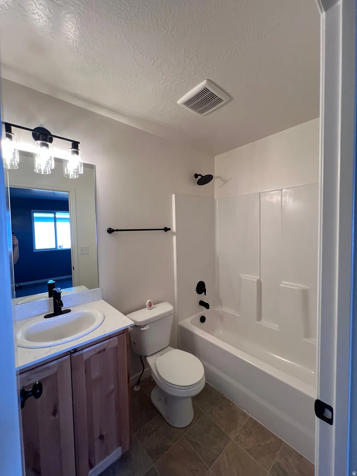 Full bathroom with vanity, shower / washtub combination, and a textured ceiling