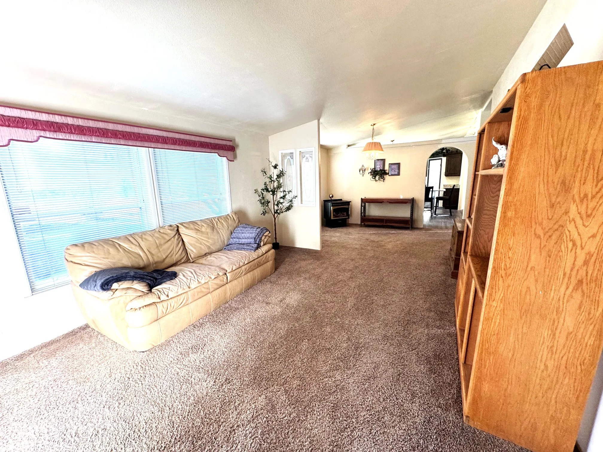Living area featuring arched walkways and dark colored carpet
