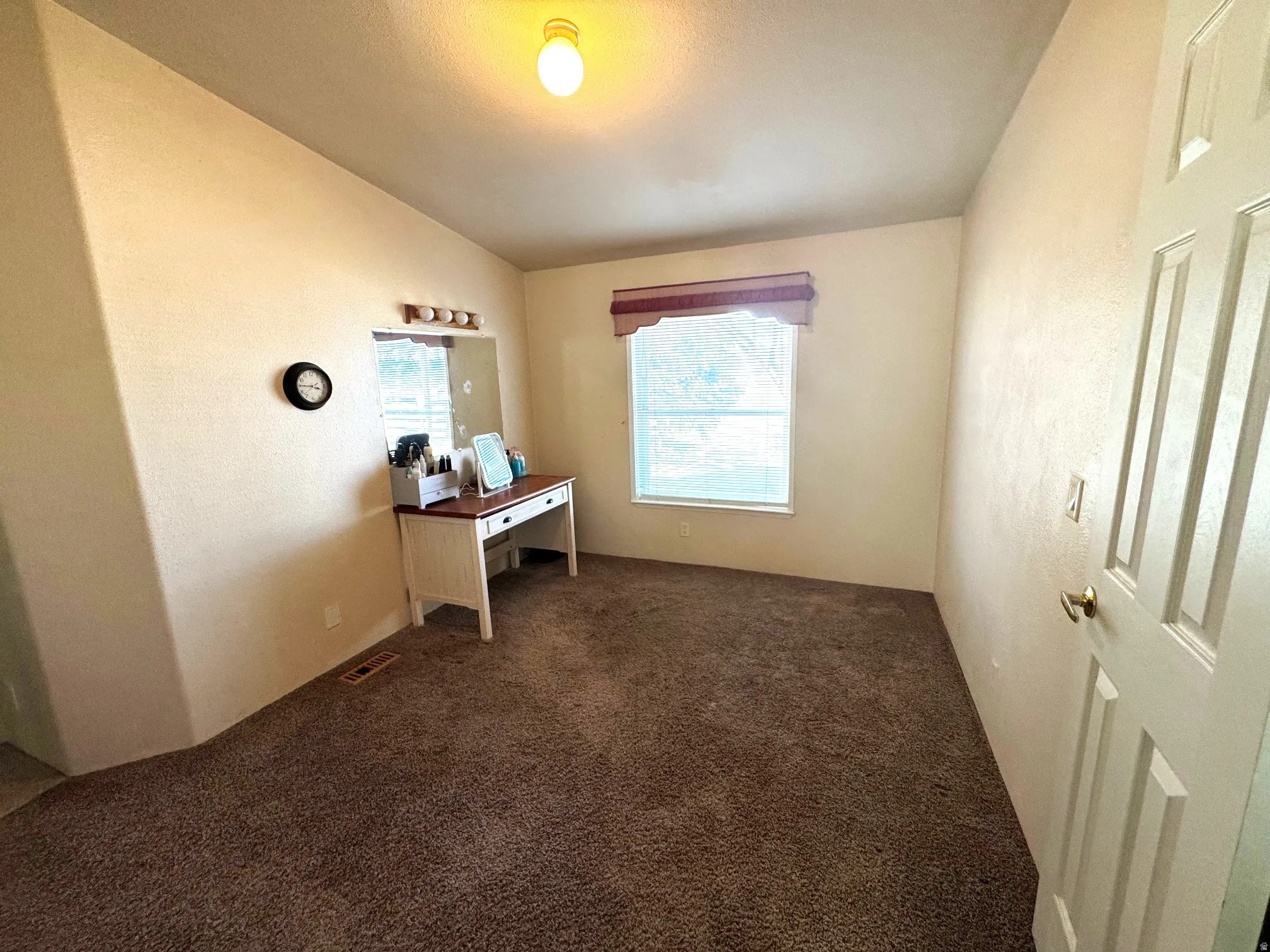 Office featuring dark carpet and a textured wall