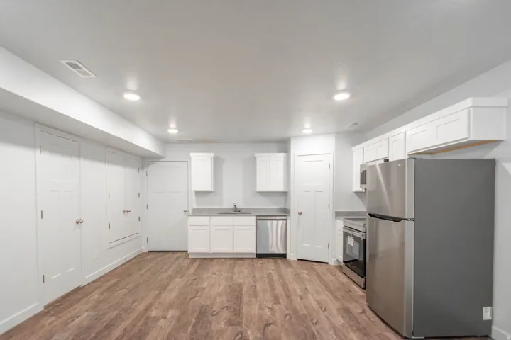 Kitchen featuring stainless steel appliances, white cabinets, light wood-style flooring, and recessed lighting