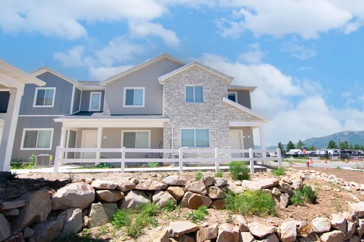 View of front of property with a mountain view, a porch, stone siding, and board and batten siding