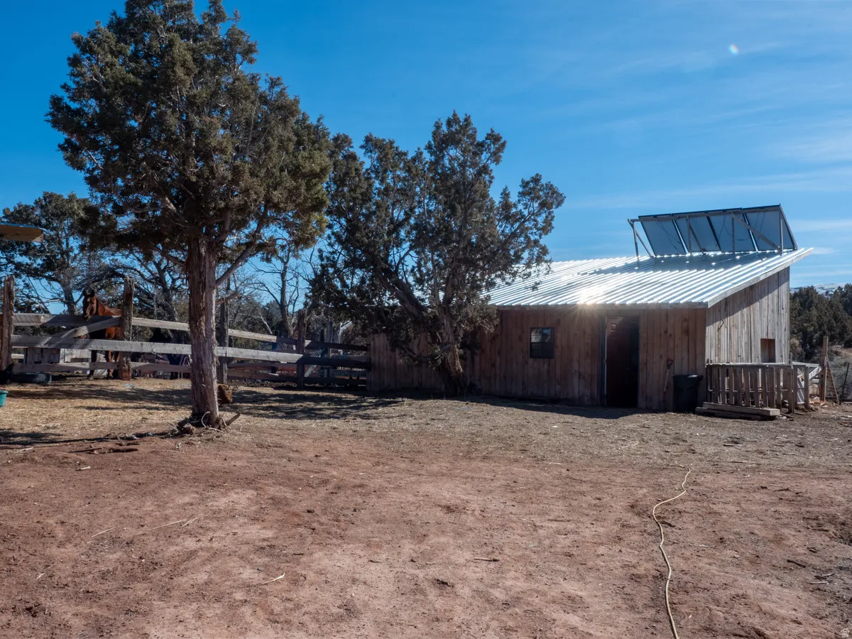View of home's exterior with an outdoor structure, a pole building, and a metal roof