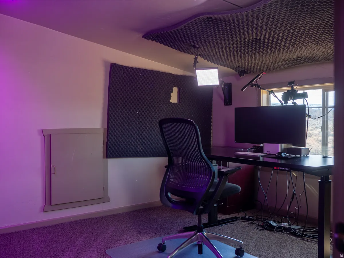 Office with light colored carpet and baseboards