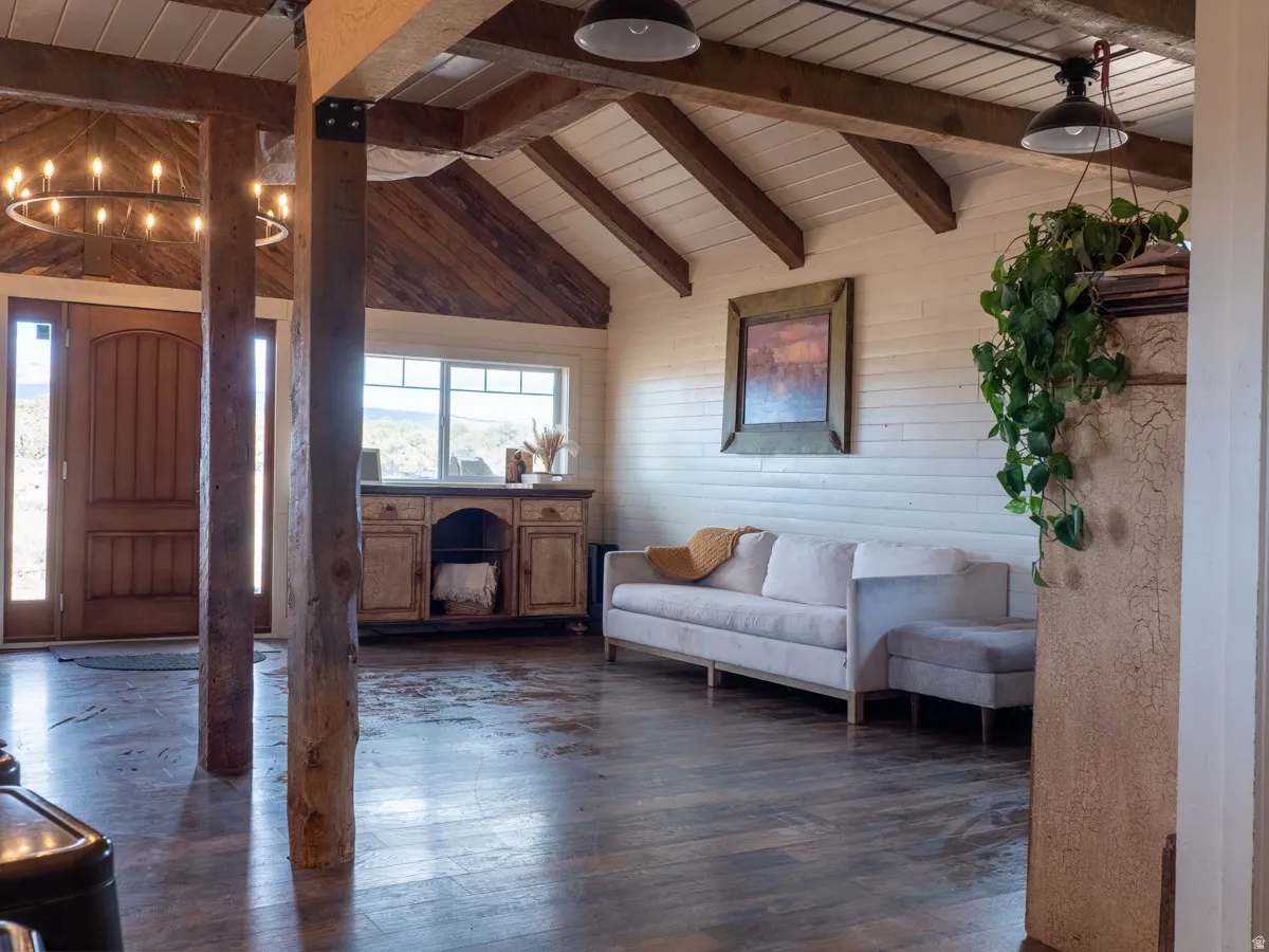 Entrance foyer with vaulted ceiling with beams, dark wood-style floors, wood ceiling, and wood walls