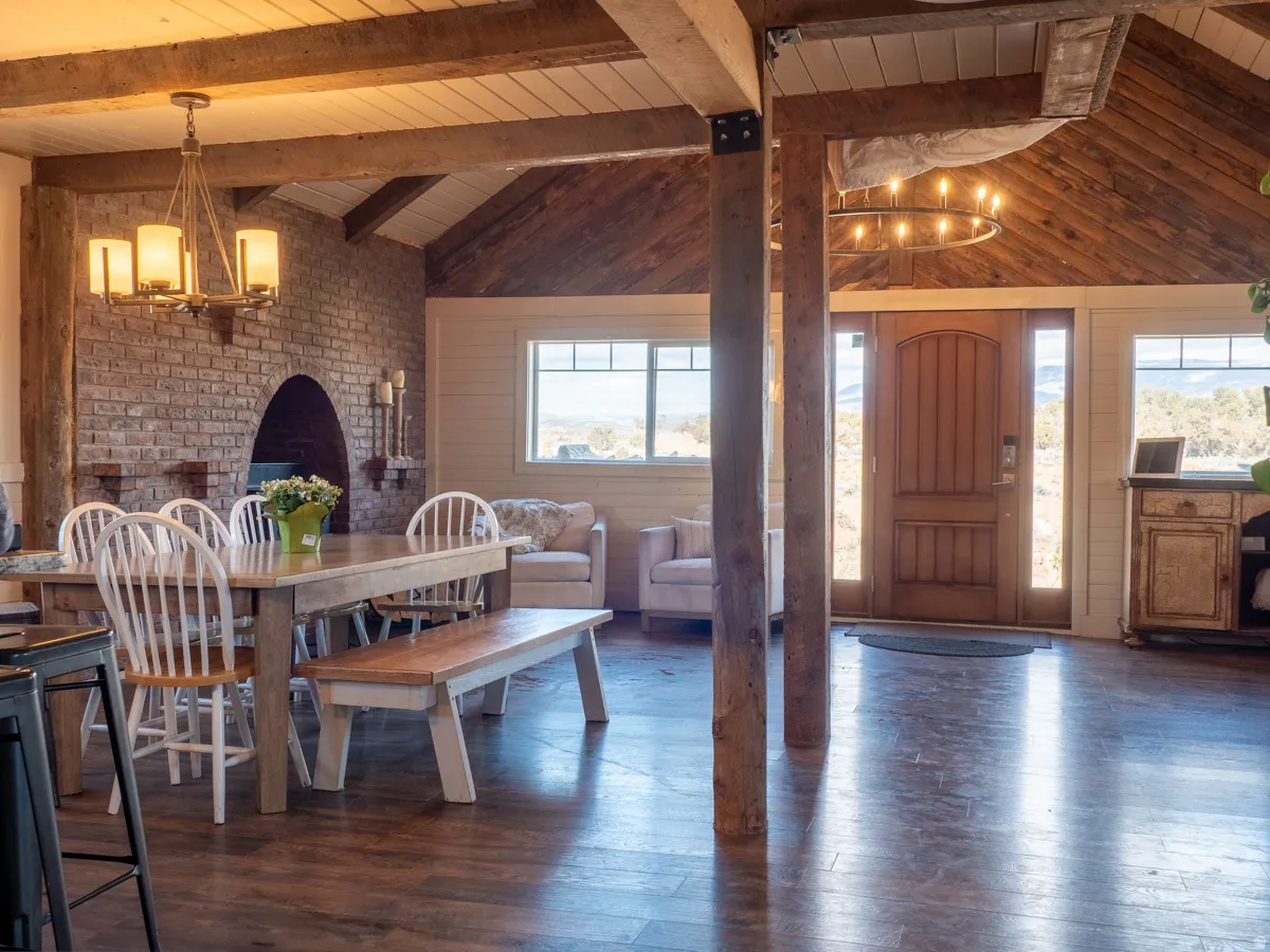 Dining area featuring a chandelier, vaulted ceiling with beams, dark wood finished floors, and wooden ceiling