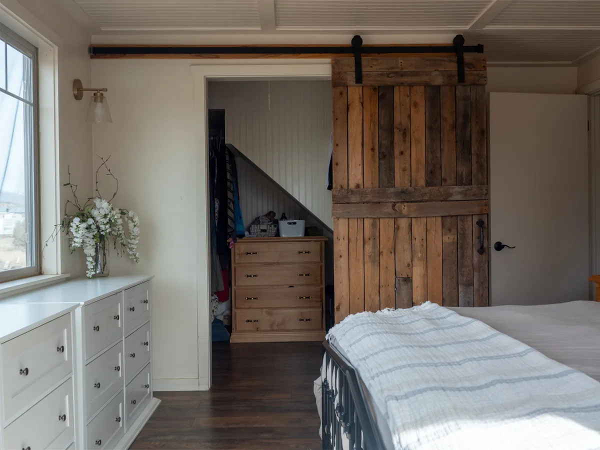 Bedroom with dark wood finished floors and a barn door