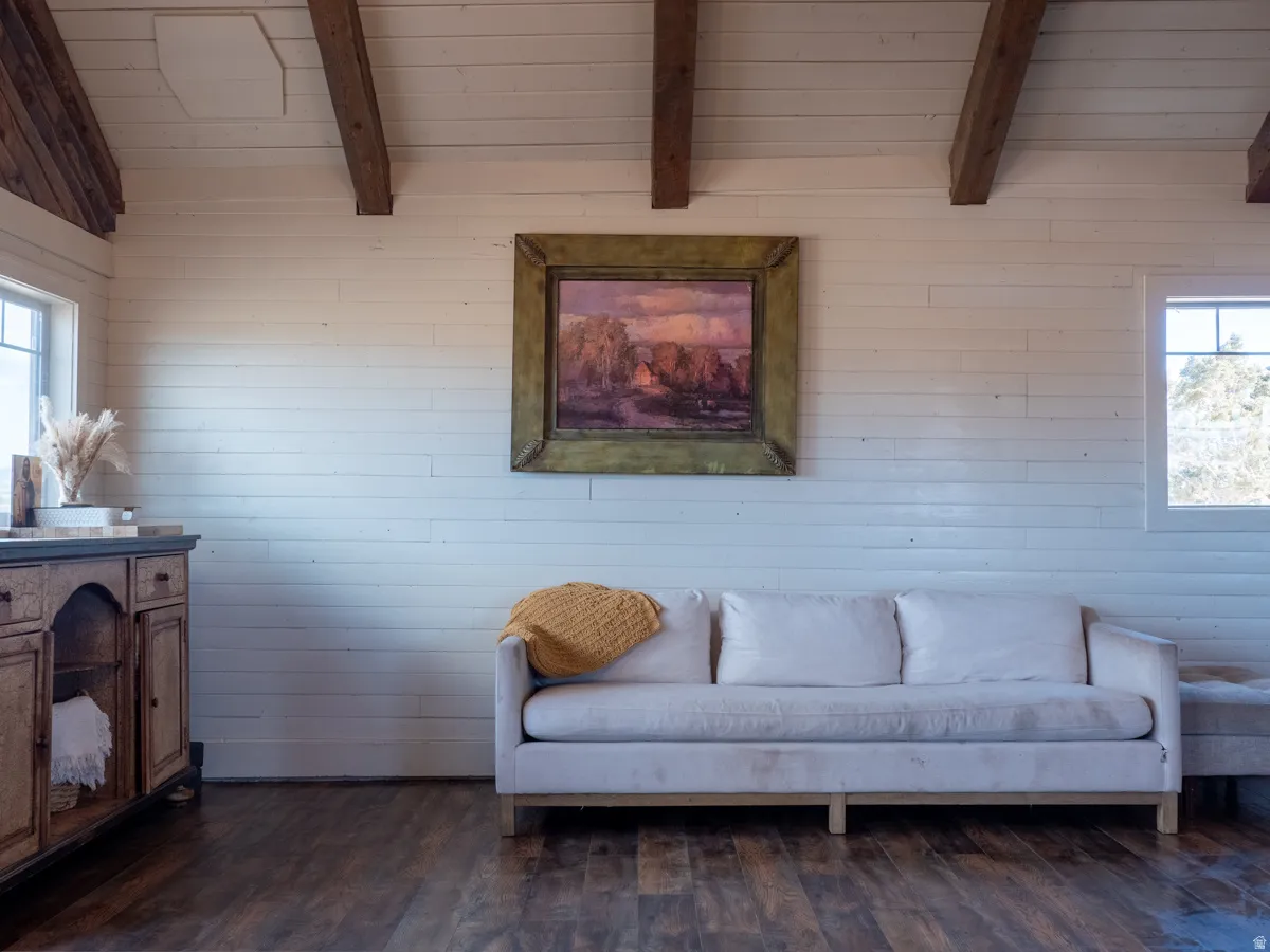 Living area with dark wood-type flooring and a wood ceiling with exposed beams