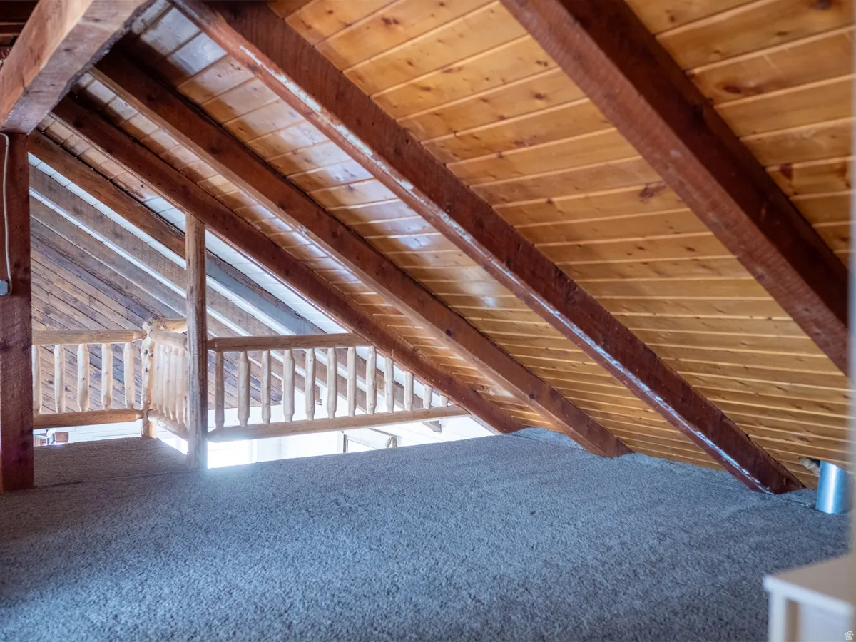 Bonus room featuring wood ceiling, carpet flooring, and vaulted ceiling with beams
