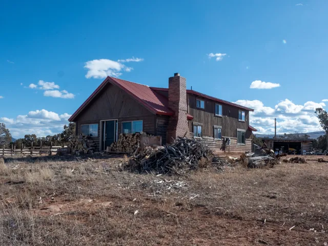 Rear view of house featuring a metal roof and a chimney