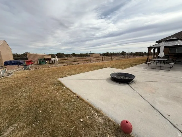 Fenced yard with a patio, a fire pit, and a gazebo