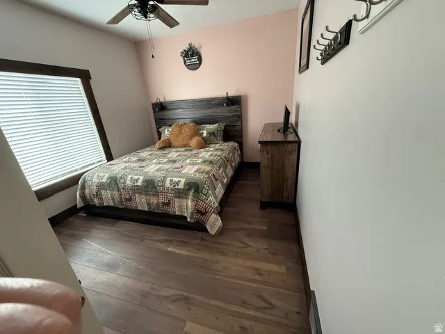 Bedroom with dark wood-type flooring and ceiling fan