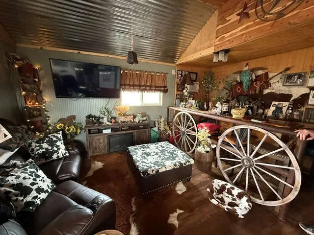 Living room with vaulted ceiling and wood walls