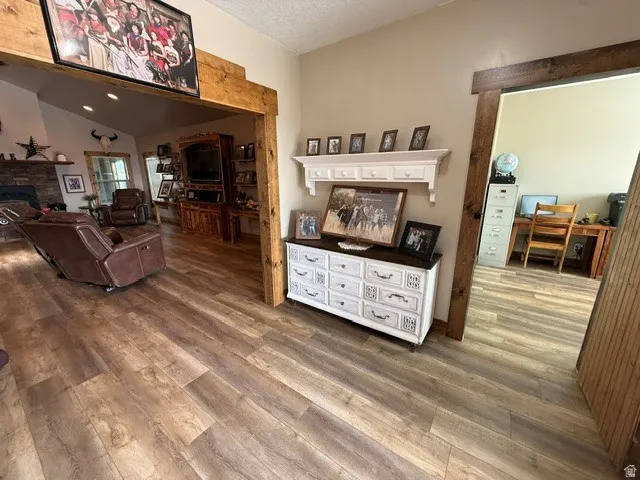 Living area featuring wood finished floors and a stone fireplace