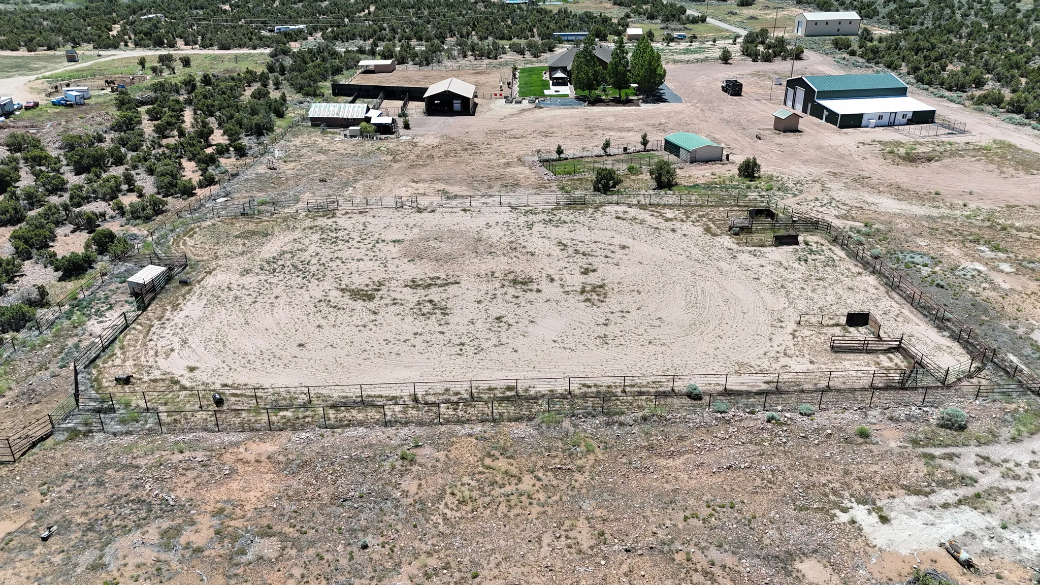 Expansive outdoor arena featuring perimeter fencing and several smaller fenced enclosures