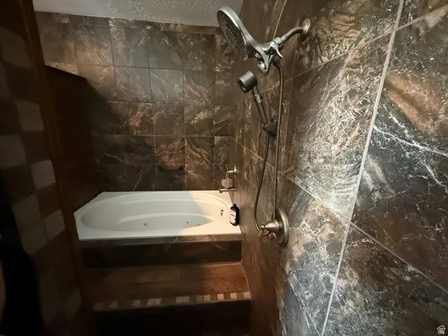 Bathroom featuring a tub with jets and a shower
