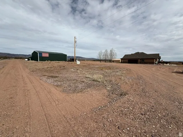 View of yard with driveway, a view of countryside, and an outdoor structure