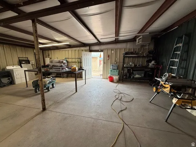 Basement with a garage, washer / dryer, metal wall, and a heating unit