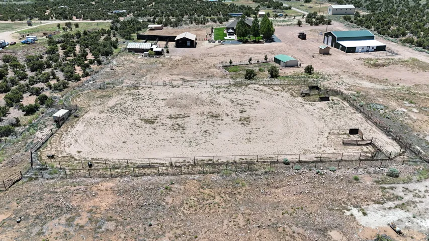 Expansive outdoor arena featuring perimeter fencing and several smaller fenced enclosures