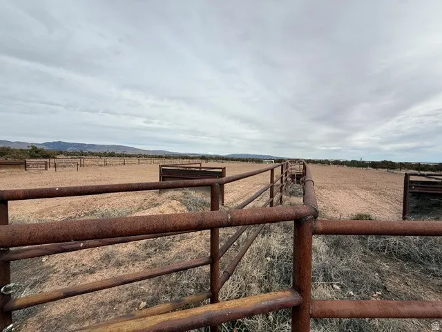 View of yard with an enclosed riding area, a view of countryside, and a mountain view