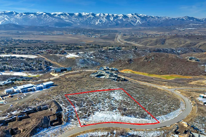 Aerial view of property's location featuring a mountainous background and property parcel outlined