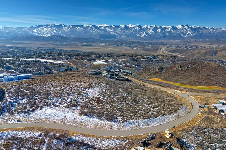 Aerial view of property and surrounding area with a mountain backdrop
