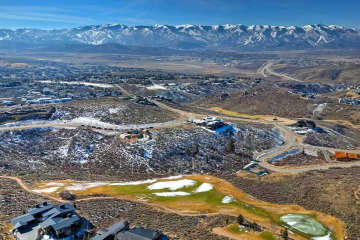 Aerial view of property and surrounding area with a mountain backdrop