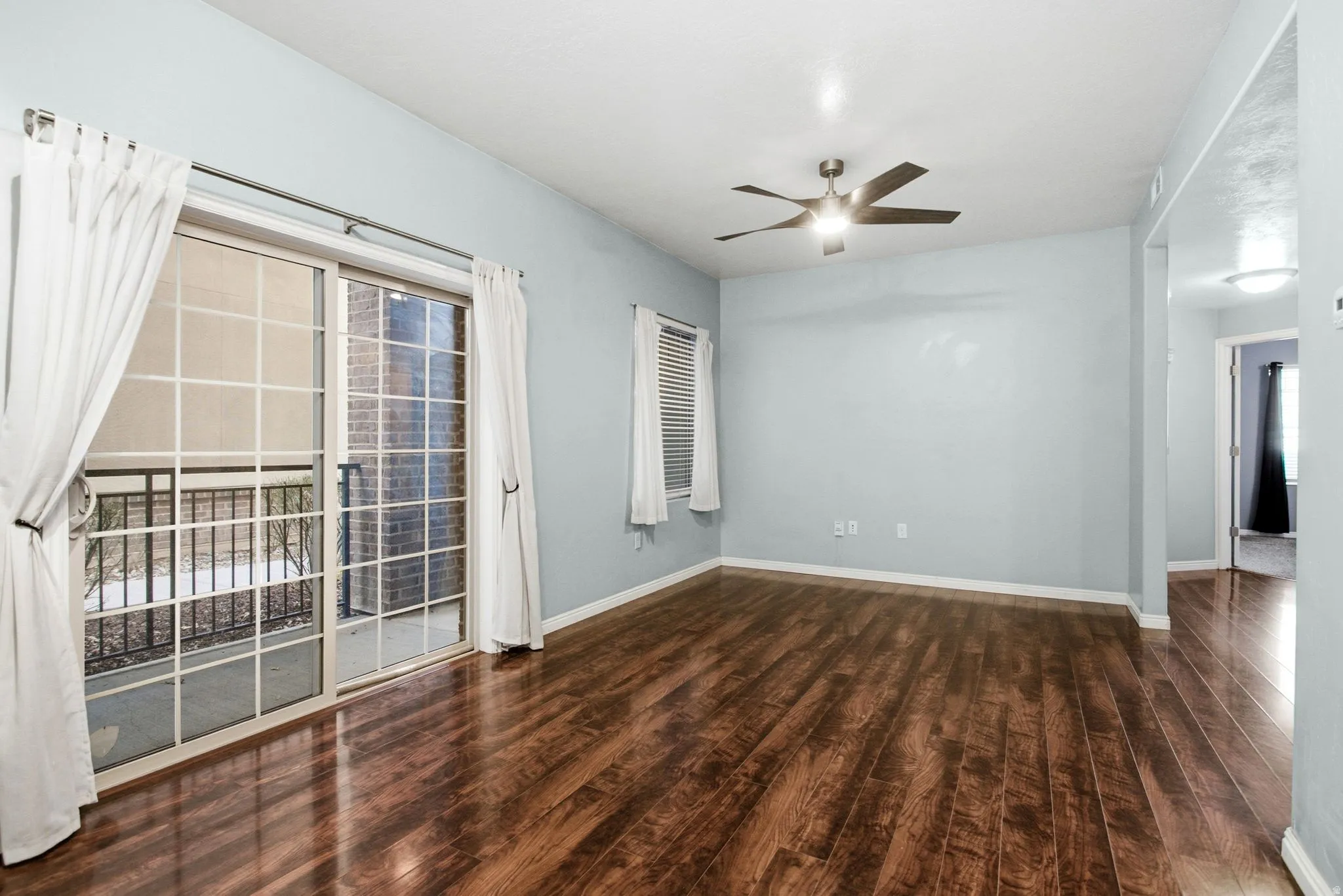Spare room featuring dark wood-style flooring and ceiling fan