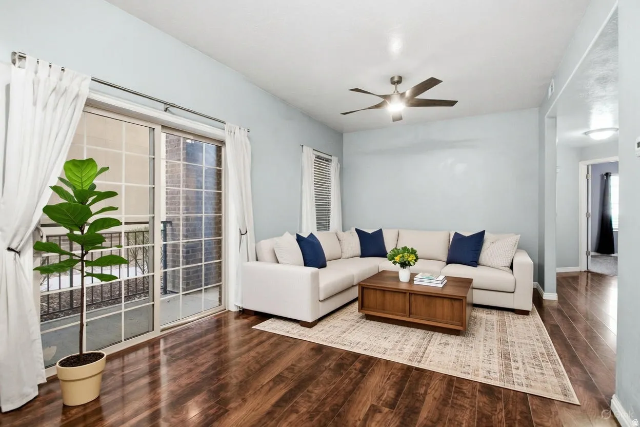 Living room featuring dark wood-style floors and ceiling fan