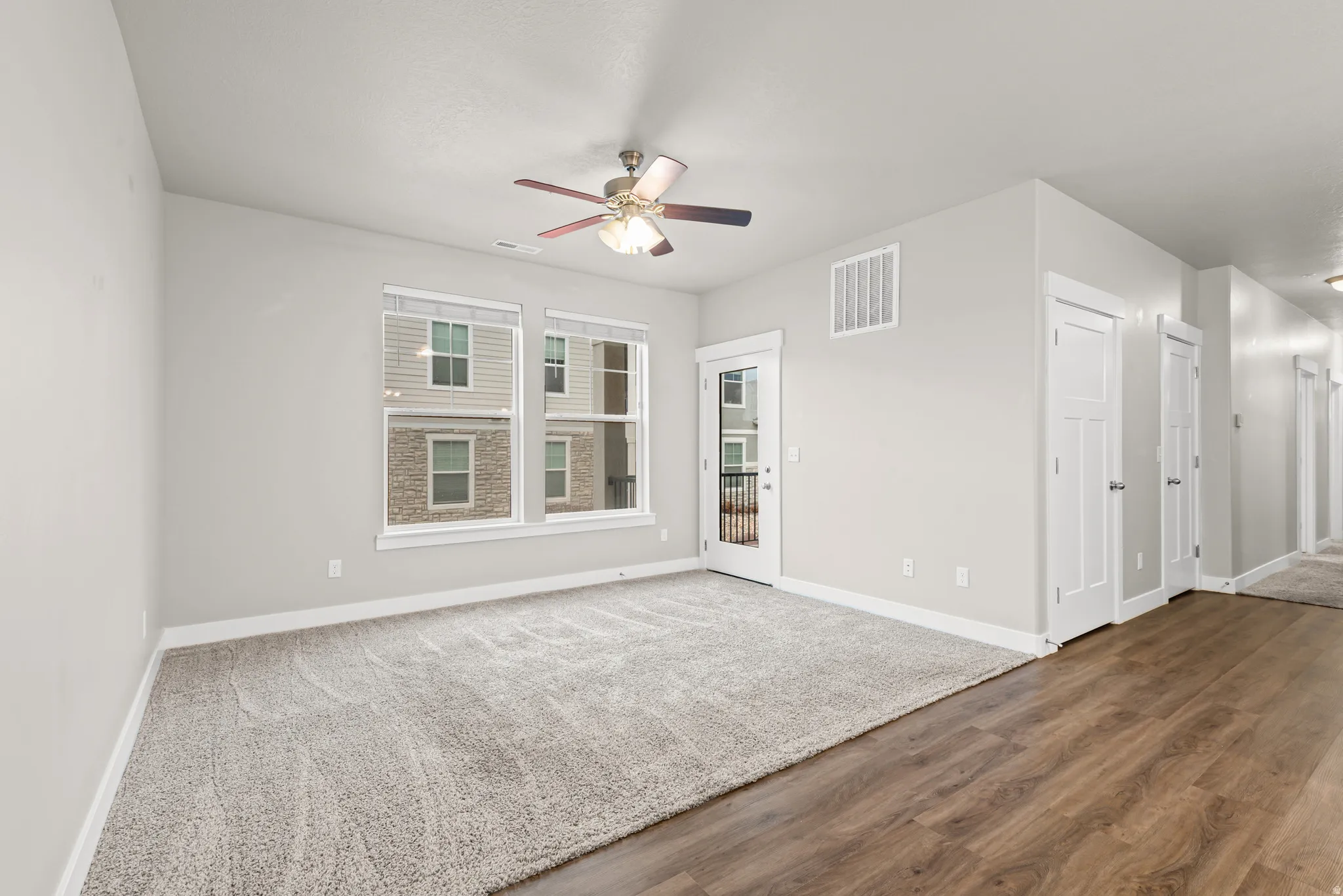Unfurnished room with dark wood-style flooring and a ceiling fan