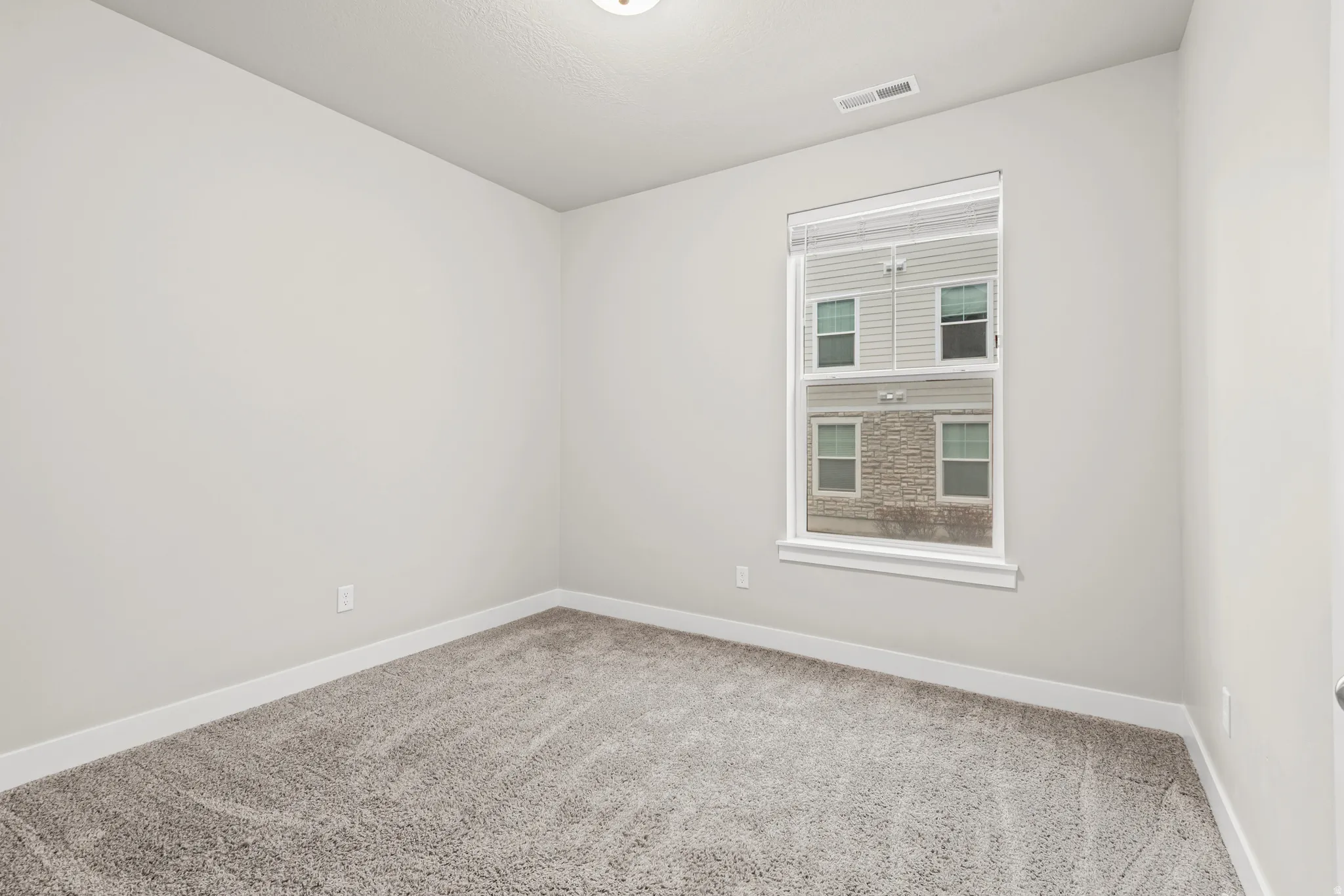 Spare room with baseboards and light carpet