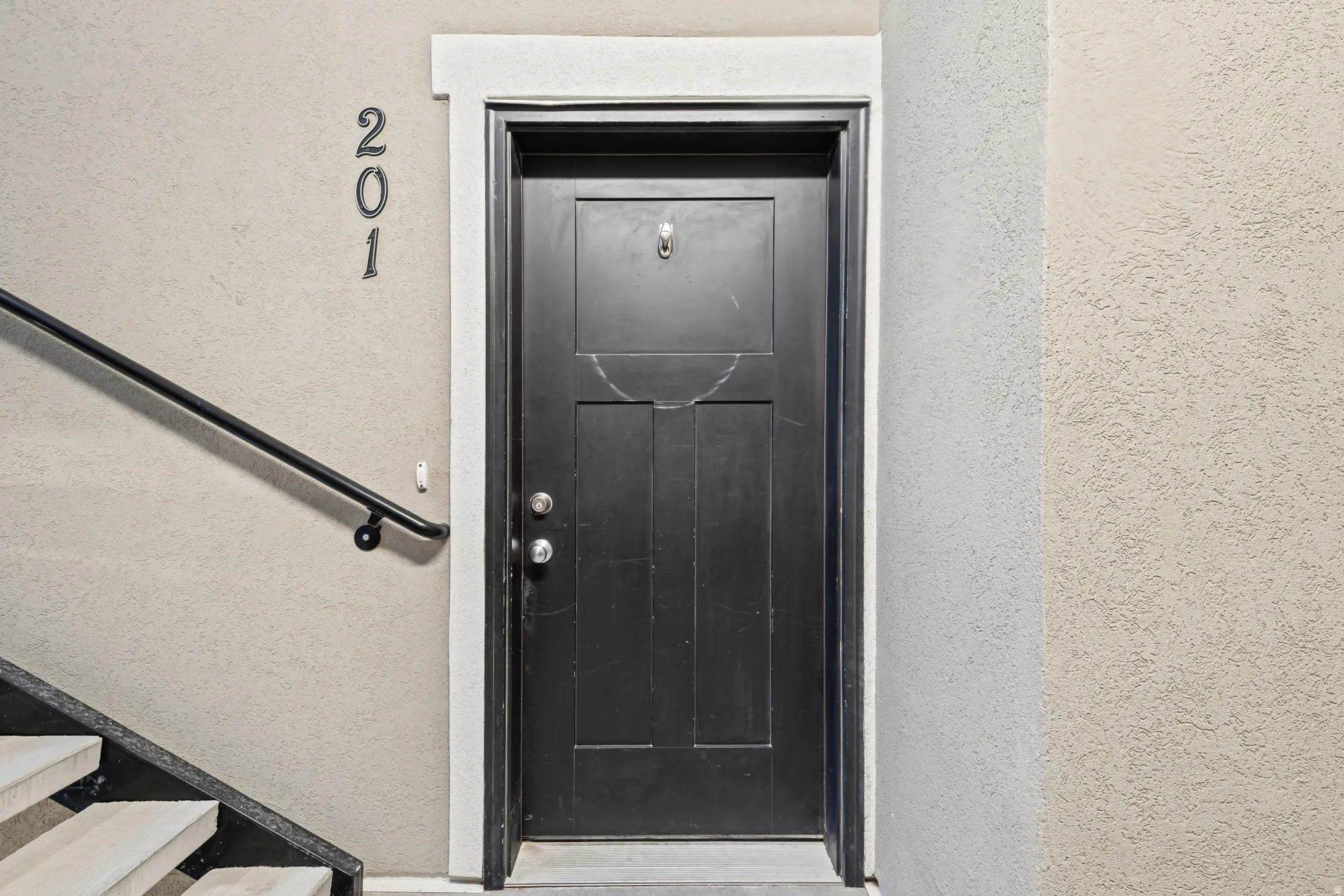 Property entrance with stucco siding
