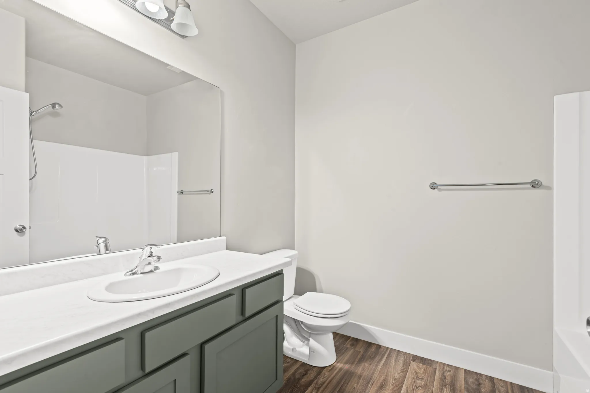 Full bath with vanity and dark wood finished floors