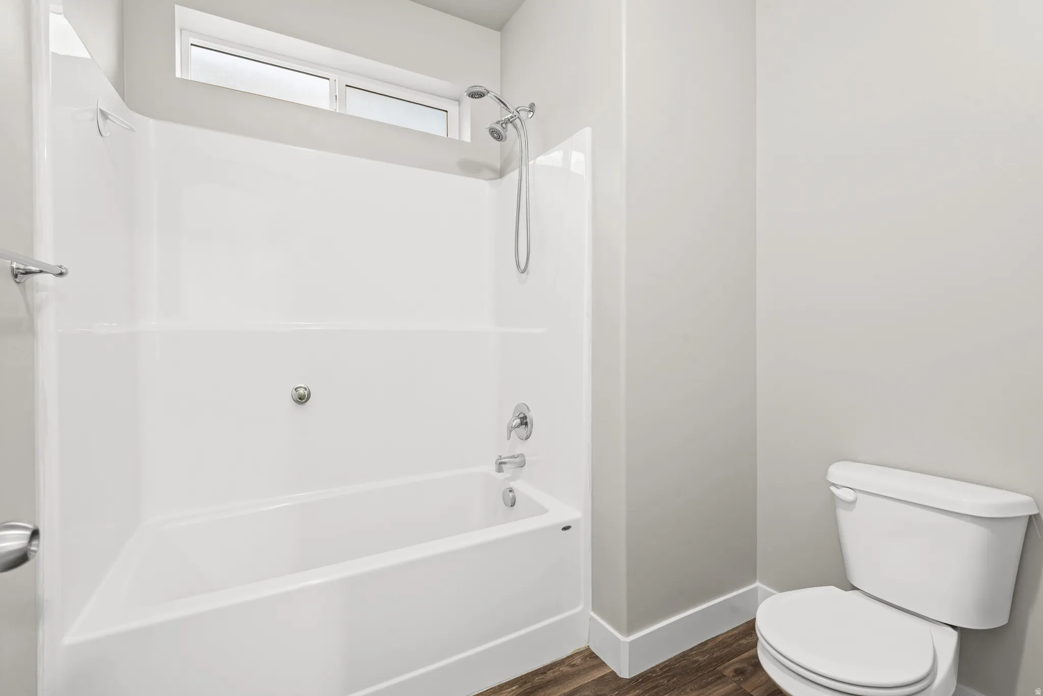 Bathroom featuring  shower combination and dark wood-style flooring