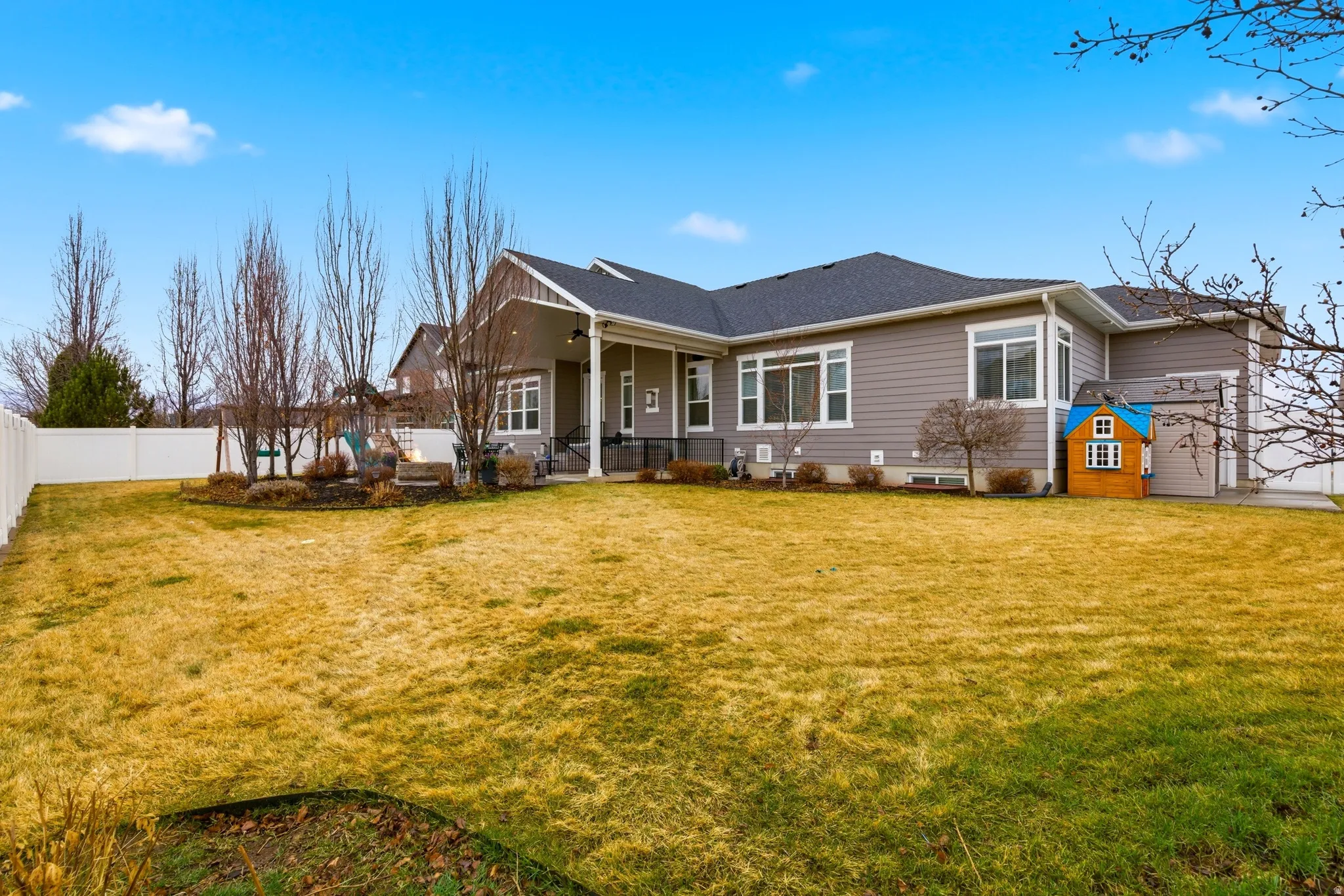 Rear view of property featuring a patio, a fenced backyard, and a shingled roof