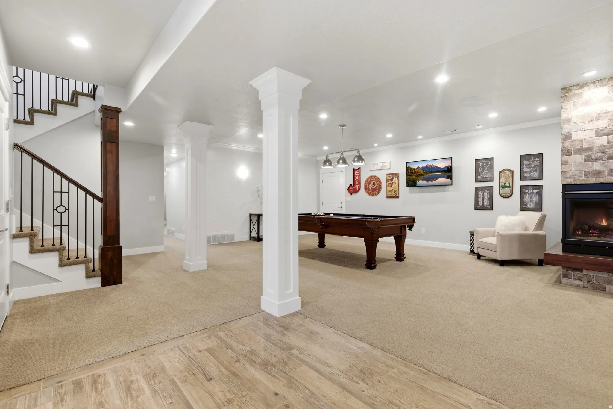 Recreation room featuring a warm lit fireplace, light wood finished floors, pool table, light carpet, and recessed lighting