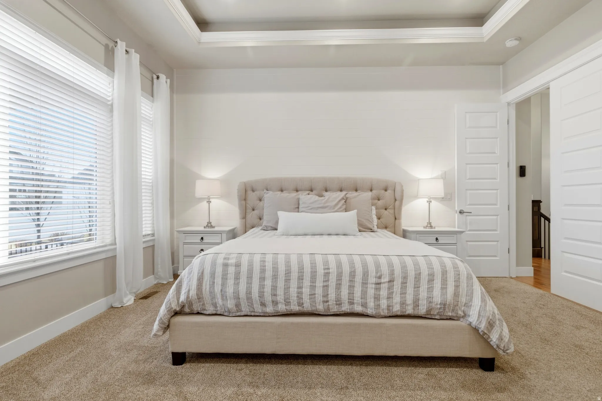 Bedroom featuring a tray ceiling and carpet flooring