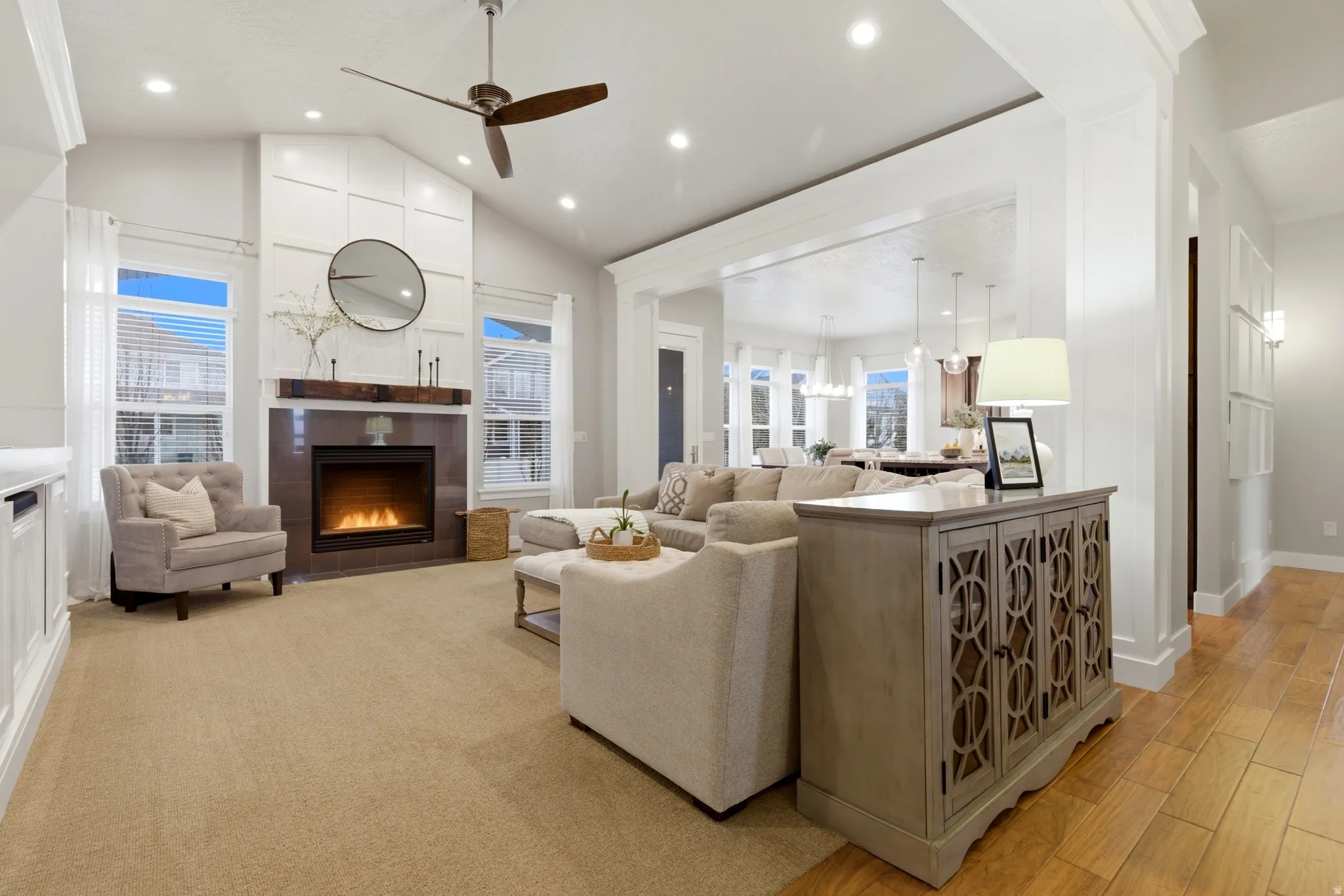 Living room featuring a tile fireplace, a ceiling fan, lofted ceiling, recessed lighting, and light wood-type flooring
