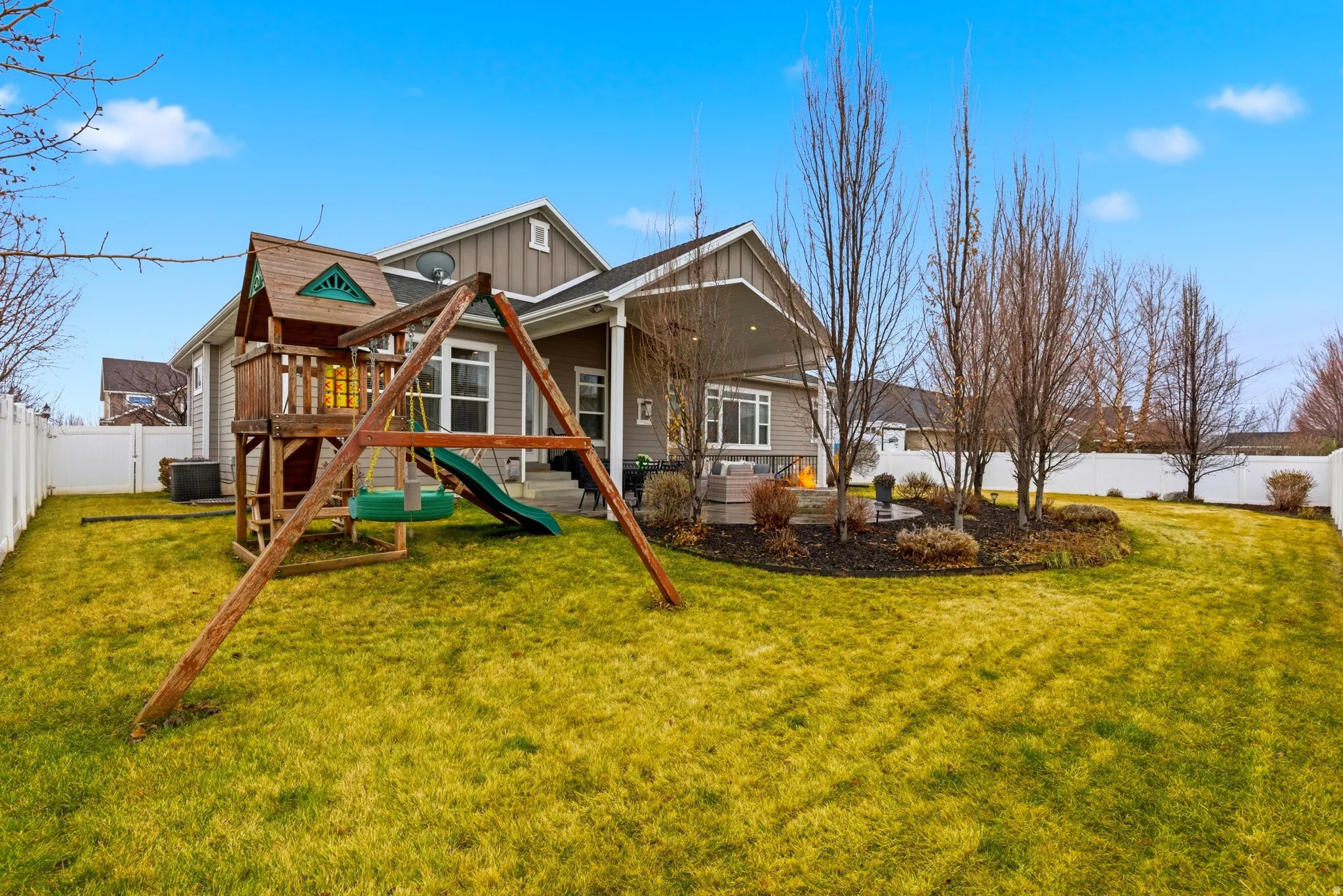 Back of property featuring a fenced backyard, board and batten siding, and a playground