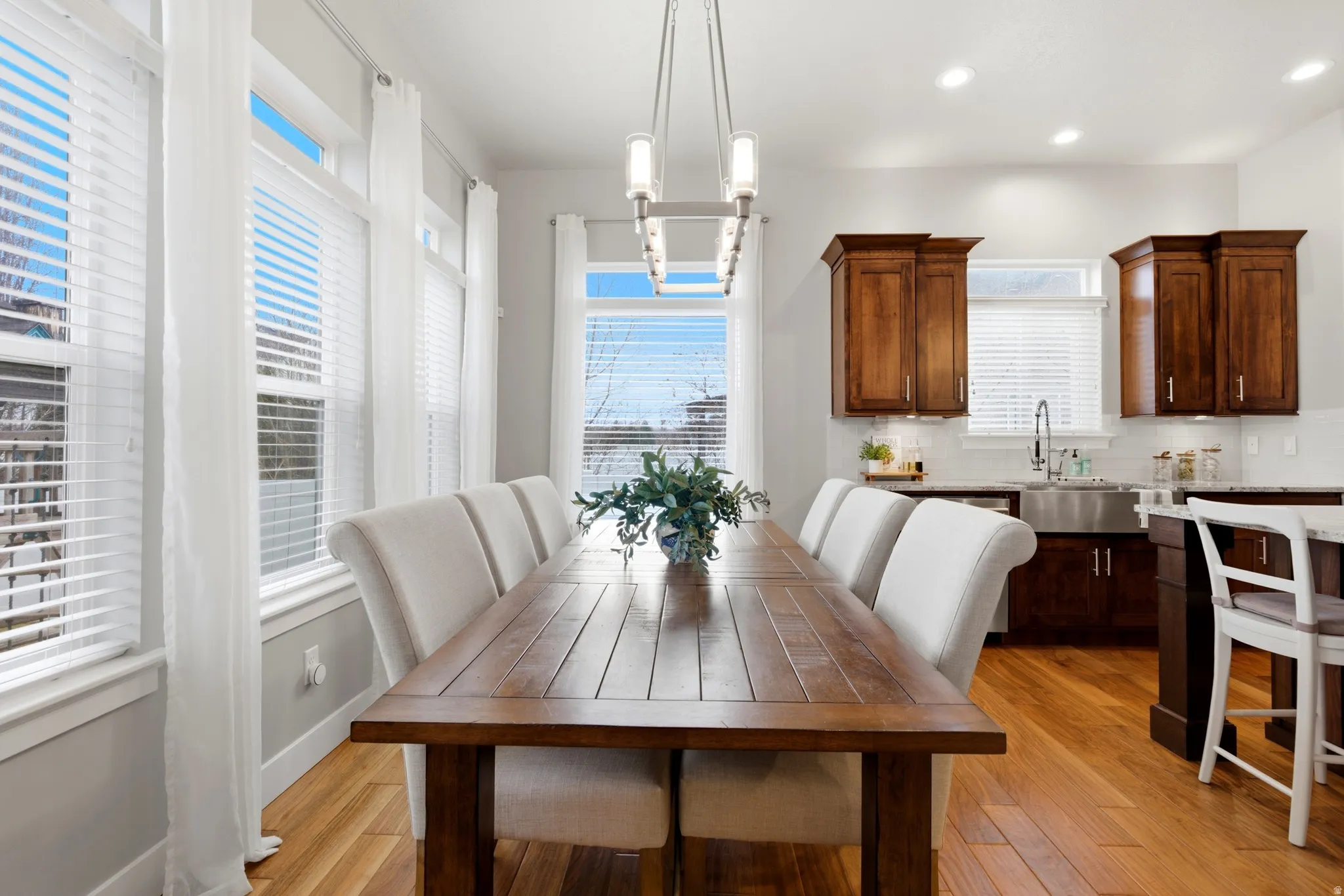 Dining area with light wood-style flooring and recessed lighting