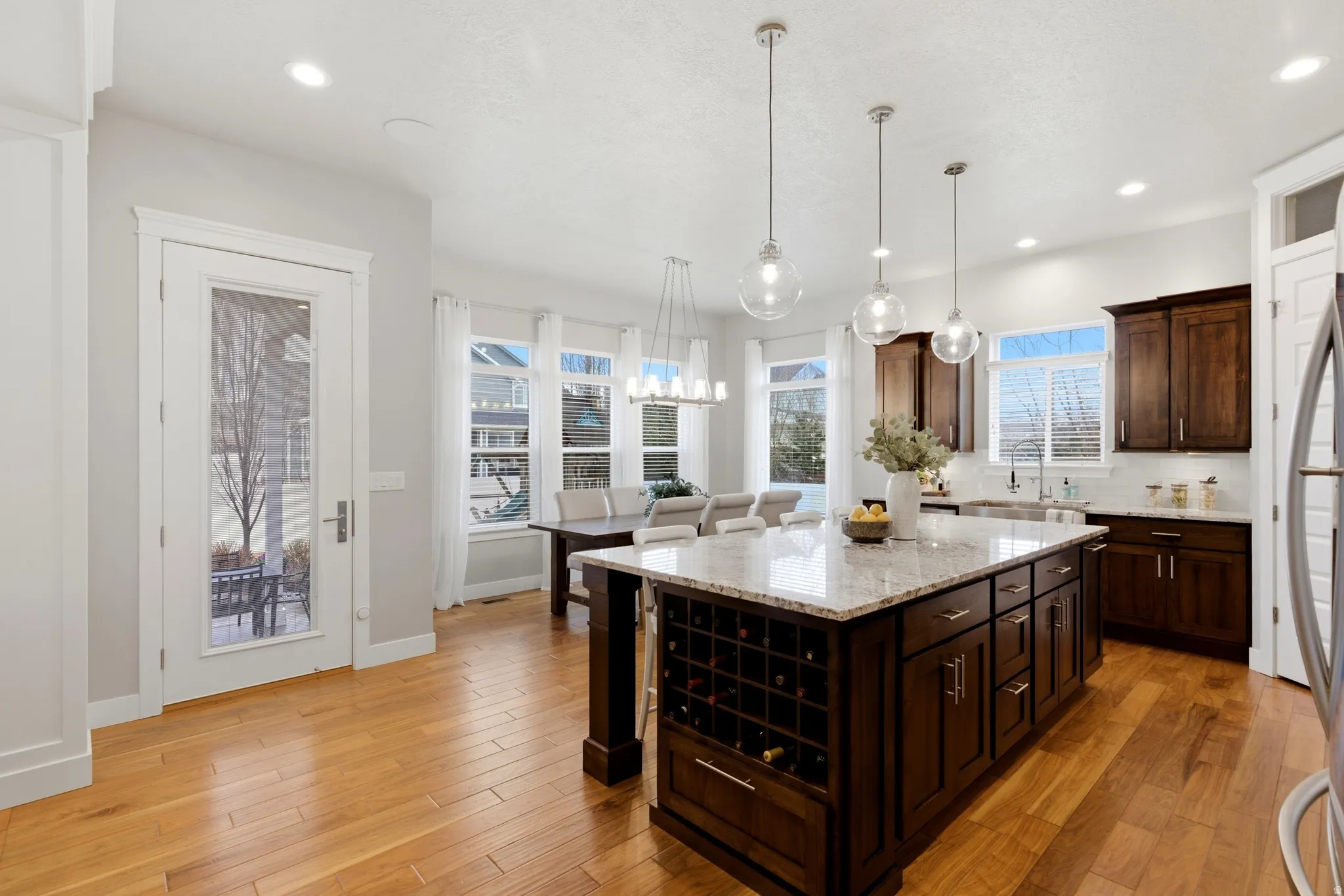 Kitchen with a kitchen breakfast bar, light stone countertops, dark wood finish cabinets, and a kitchen island