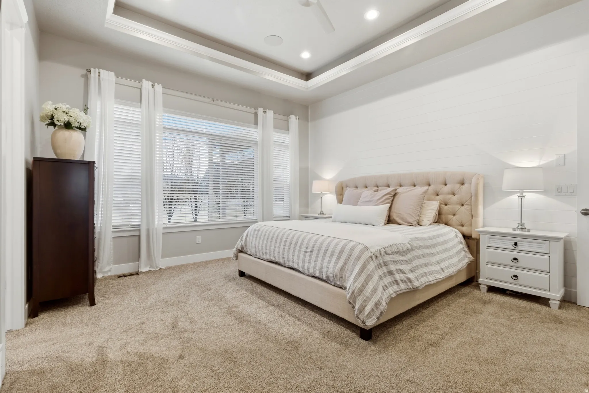 Bedroom with a tray ceiling, light carpet, a ceiling fan, and recessed lighting