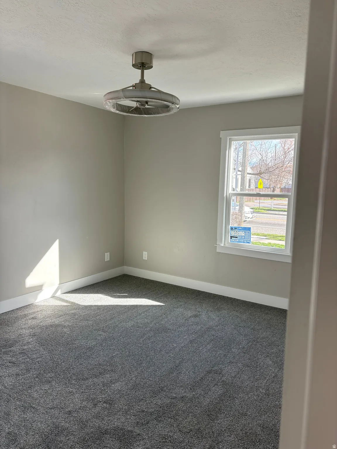 Bedroom 1 light colored carpet and a textured ceiling ceiling fan/light