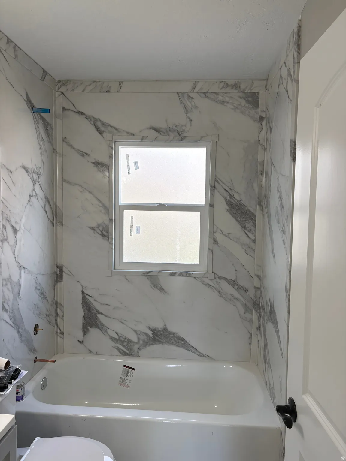 Bathroom with vanity and a combined bath / shower with marble appearance